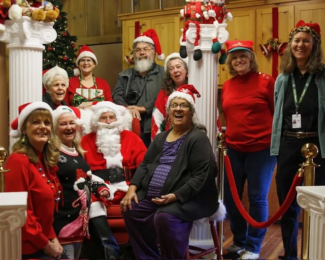 Board members in Santa hats with Santa inside the Hall, Christmas 2024.
